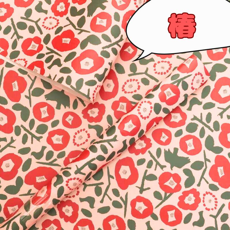 赤い椿と緑の葉が描かれた和風包装紙、春らしい花柄デザイン