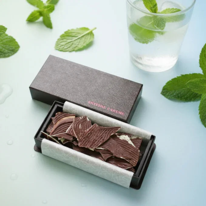 高級チョコレート、ミント葉とグラスの水と共に